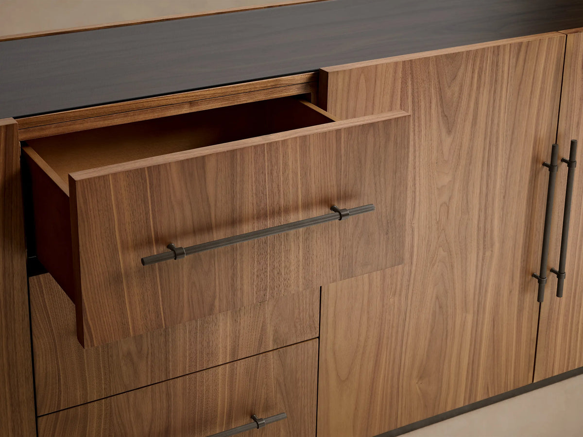 Close-up of Piermont Modular Reeded Media Cabinet's dark walnut reeded door with bronze pull, revealing interior shelves.