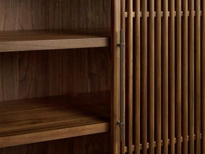 Piermont Modular Reeded Media Cabinet close-up. Dark walnut wood, reeded top detail, open door showing internal shelves.