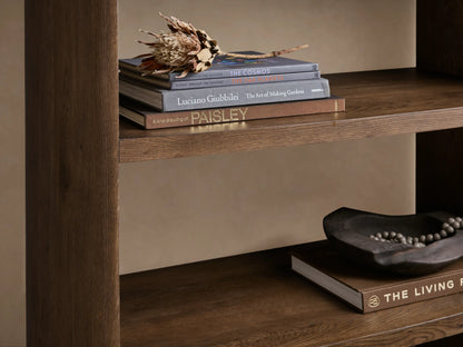 Close-up of the dark brown reclaimed white oak Redding Bookcase, showing two shelves with books and decorative objects.