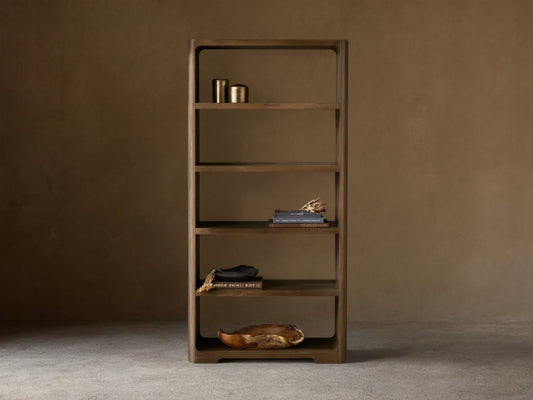 Front view of the dark reclaimed oak Redding Bookcase with five open shelves and rounded corners, styled with home decor.
