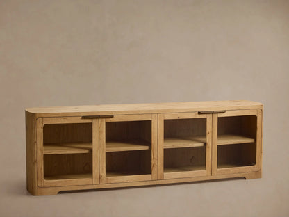 Front view of a light natural wood cabinet with four glass doors, rounded corners, interior shelves, and dark metal handles.