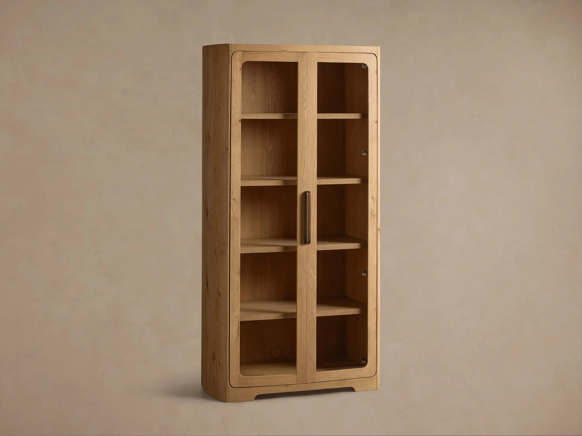 Front view of the light brown Redding Glass Cabinet, crafted from reclaimed white oak, with two glass doors, four shelves, and antique brass handle.