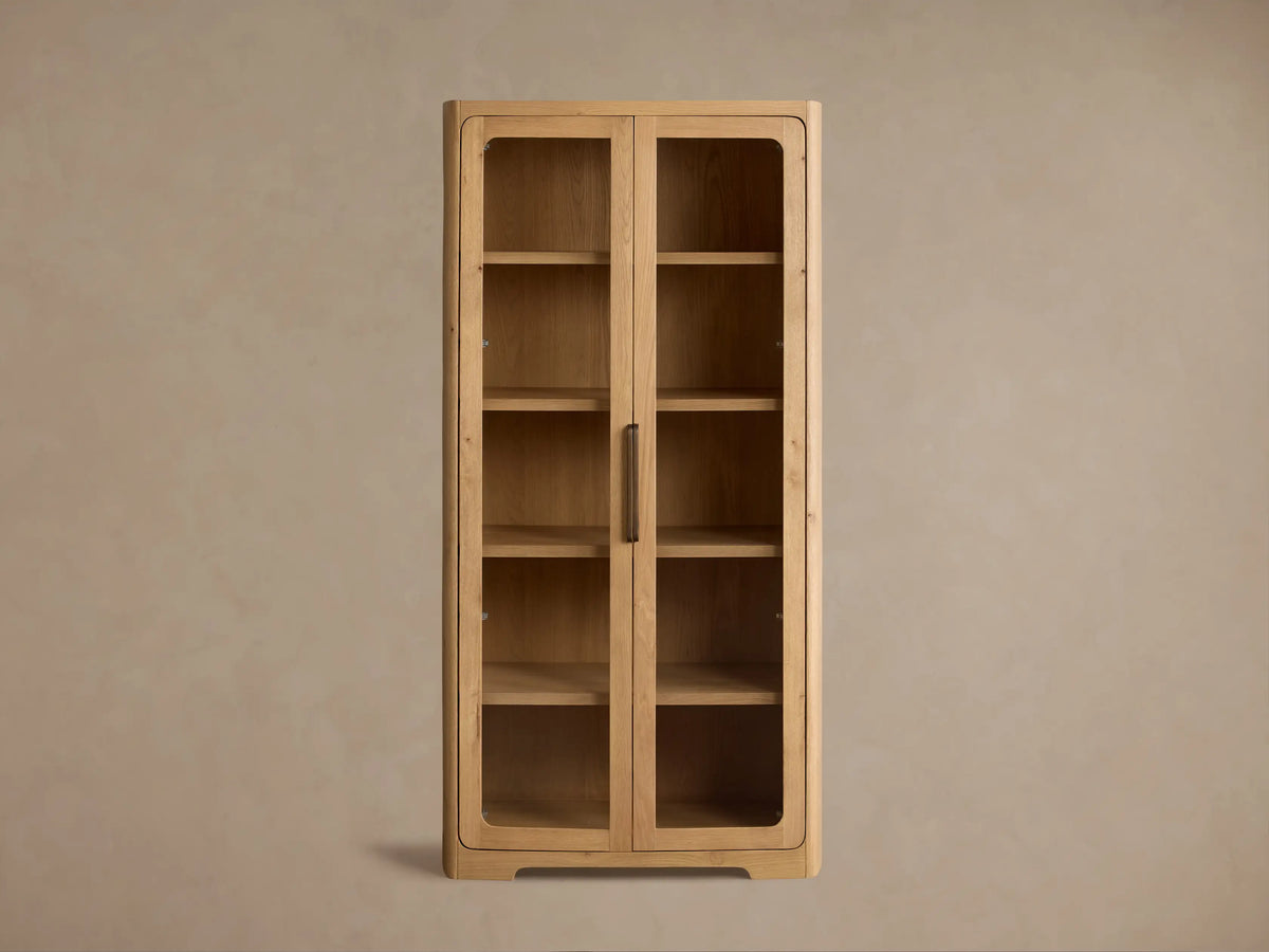 Front view of the natural reclaimed white oak Redding Glass Cabinet with two glass doors, four shelves, and antique brass hardware.