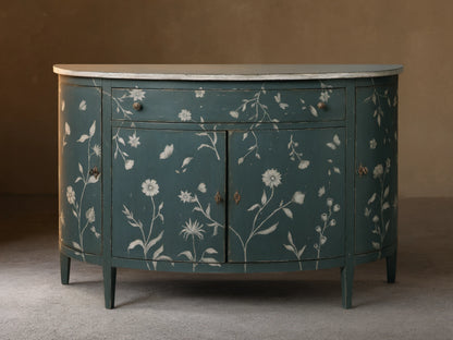 Front view of the distressed dark teal Sofia Bell'Arte Demilune Cabinet with white hand-painted floral and butterfly motifs and light top.