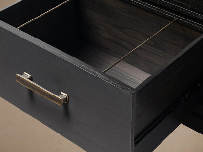 Close-up of Tremont Bookcase's dark distressed wood corner, antique brass hardware, and prominent wire-brushed grain.