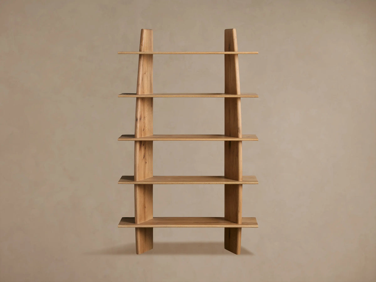 Viareggio Bookcase made of solid oak wood with five fixed shelves, displaying decorative items, against a beige wall.