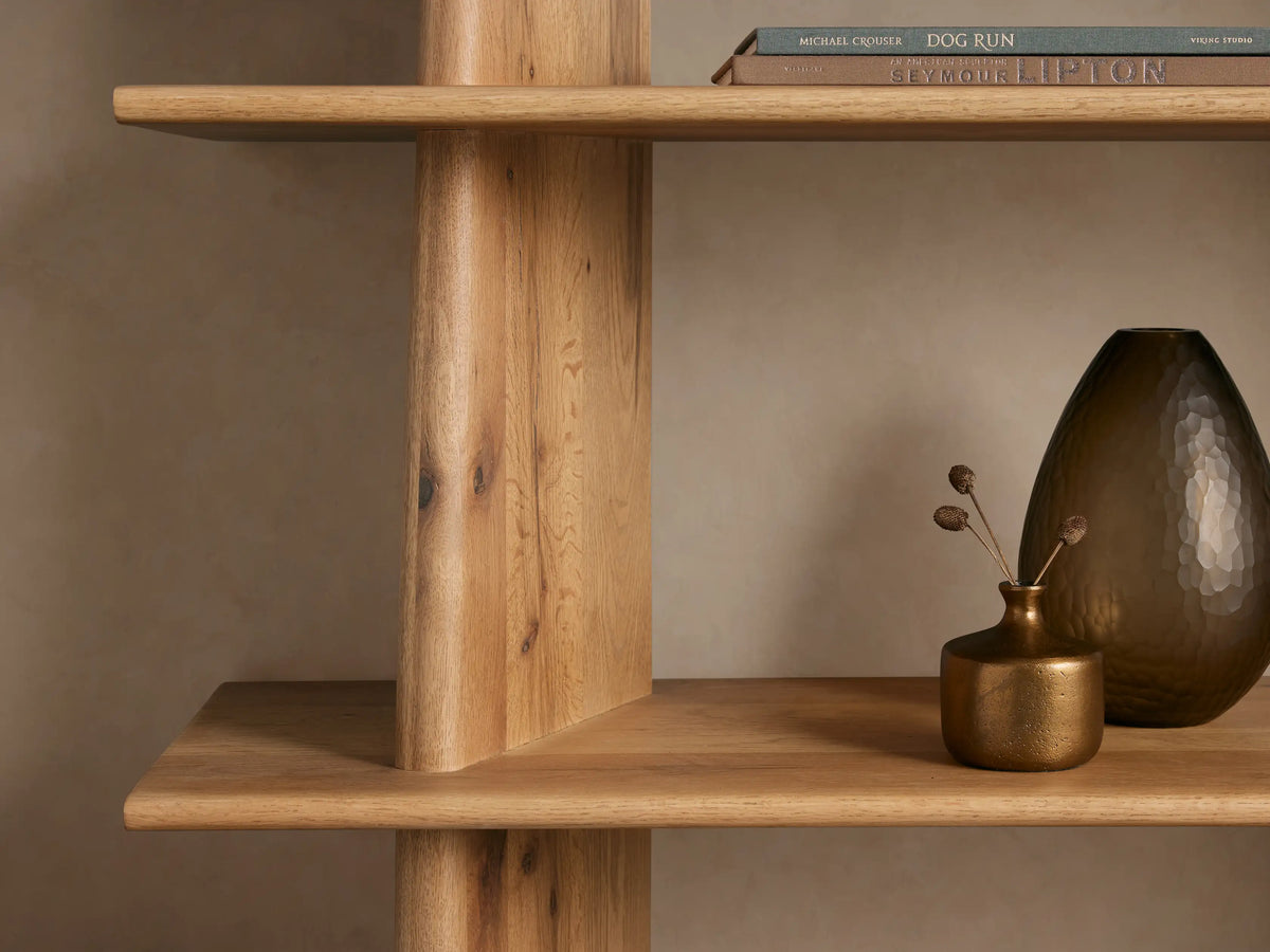 Viareggio Bookcase made of solid oak with five fixed shelves, featuring natural wood grain and a tapered design against a beige wall.