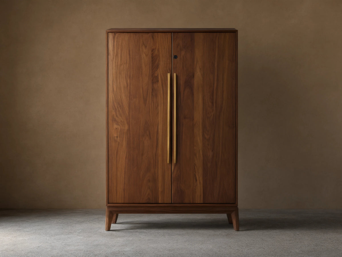 Willard Bar Cabinet, a rich dark brown walnut wood cabinet with two doors and long vertical brass handles, standing on a wooden floor.