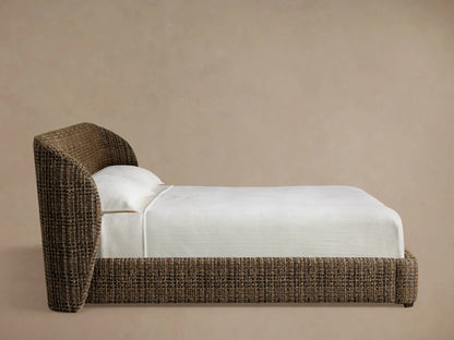 Close-up of Adalynn Bed headboard, showing textured brown, tan, gray, and black tweed-like fabric with a gentle curve.