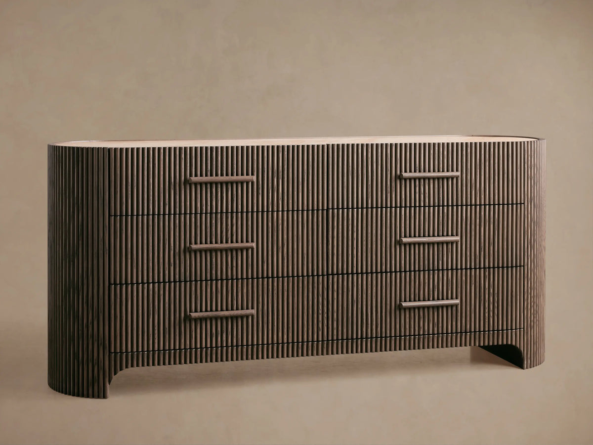 Astor Six-Drawer Dresser: Dark reeded oak dresser, 6 drawers with rectangular pulls, light marble top, curved sides, on wood floor.