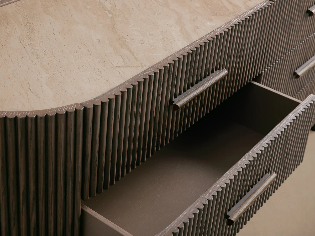 Astor Six-Drawer Dresser, dark oak wood reeding on curved sides, light marble top, six drawers with matching wooden pulls.