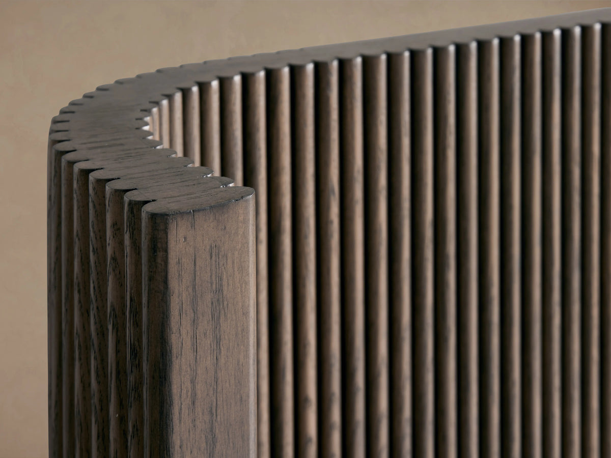 Astor Bed headboard with vertical oak wood reeding detail, curved edge, rich brown finish, close-up view.
