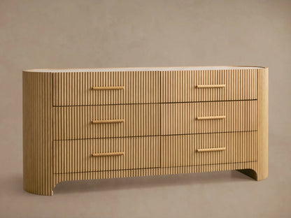 Astor Six-Drawer Dresser in light oak with vertical reeding texture and natural marble top. One drawer is open.