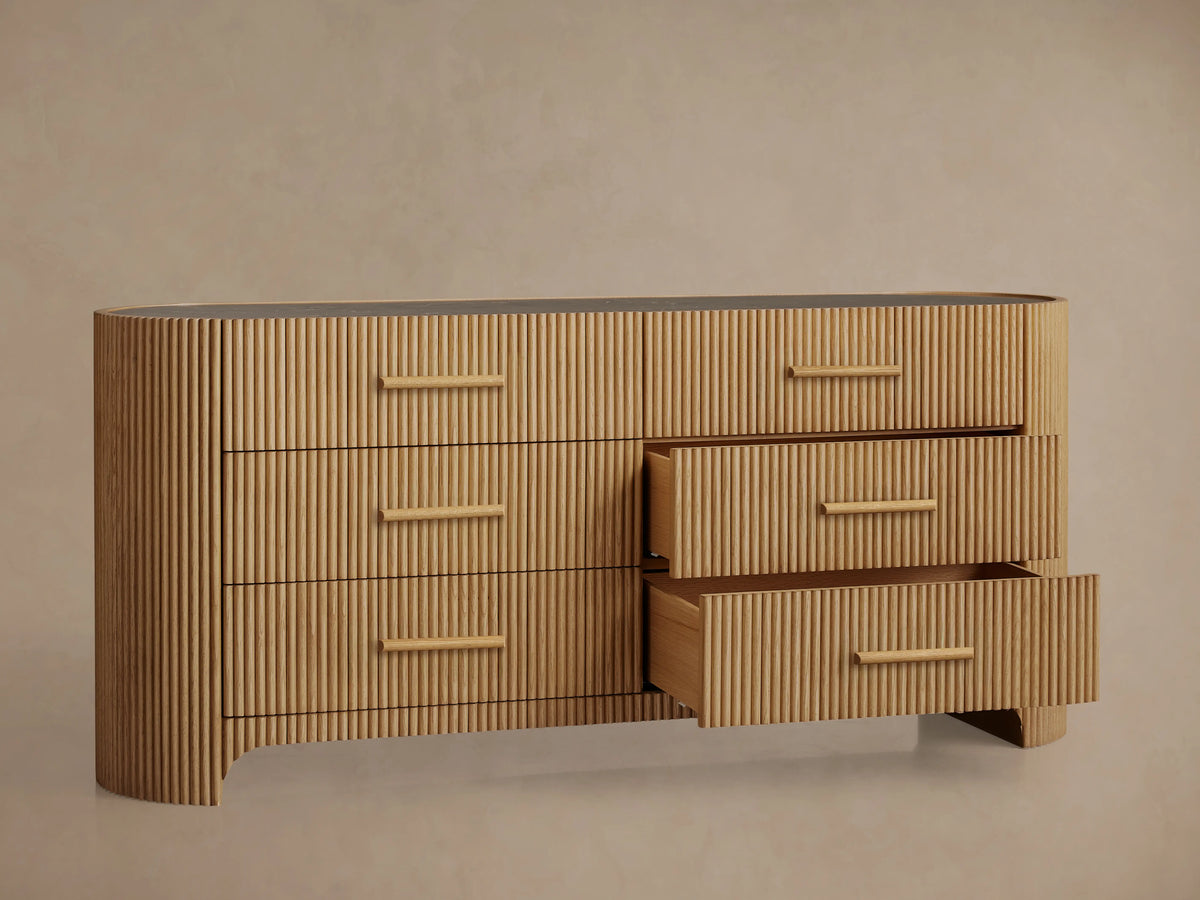 Astor Six-Drawer Dresser made of oak wood with vertical reeding, six drawers with stone pulls, and a marble top.