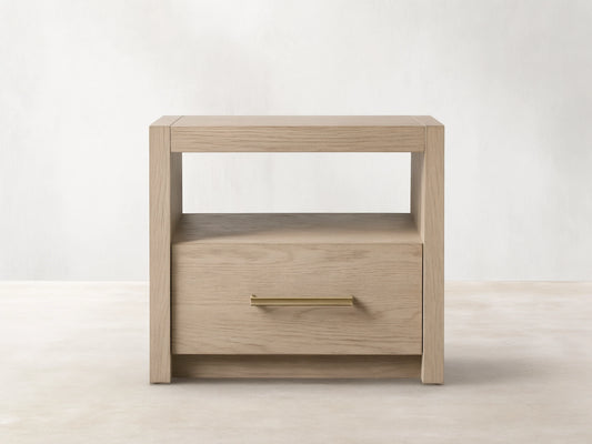 Bodhi Open Nightstand with a light oak finish features a spacious top, open shelf, and single drawer with brass handle.