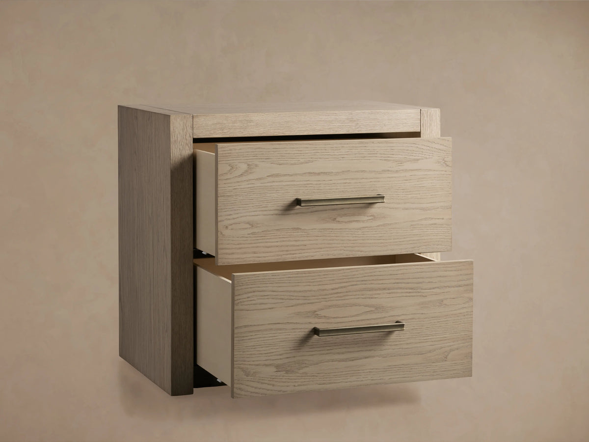 Bodhi Closed Nightstand, light wire-brushed white oak with satin sheen, two drawers partially open revealing champagne brass pulls.