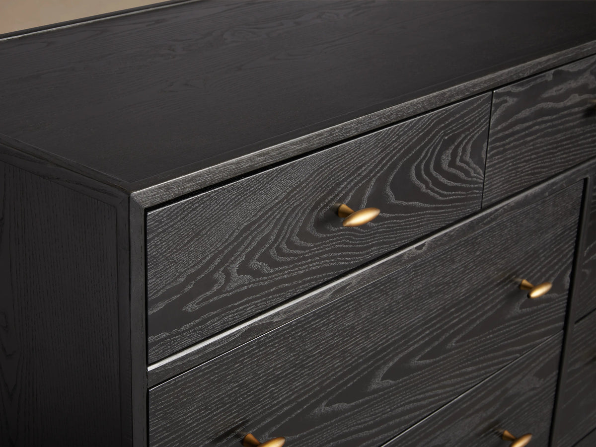 Brock Eleven-Drawer Dresser made of dark ash wood with brushed brass handles, featuring three small top drawers and eight larger ones below.