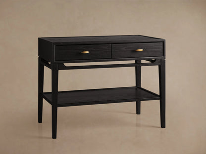 Brock Nightstand in rich ebony with two front drawers featuring brushed brass handles, additional lower shelf, on a beige background.