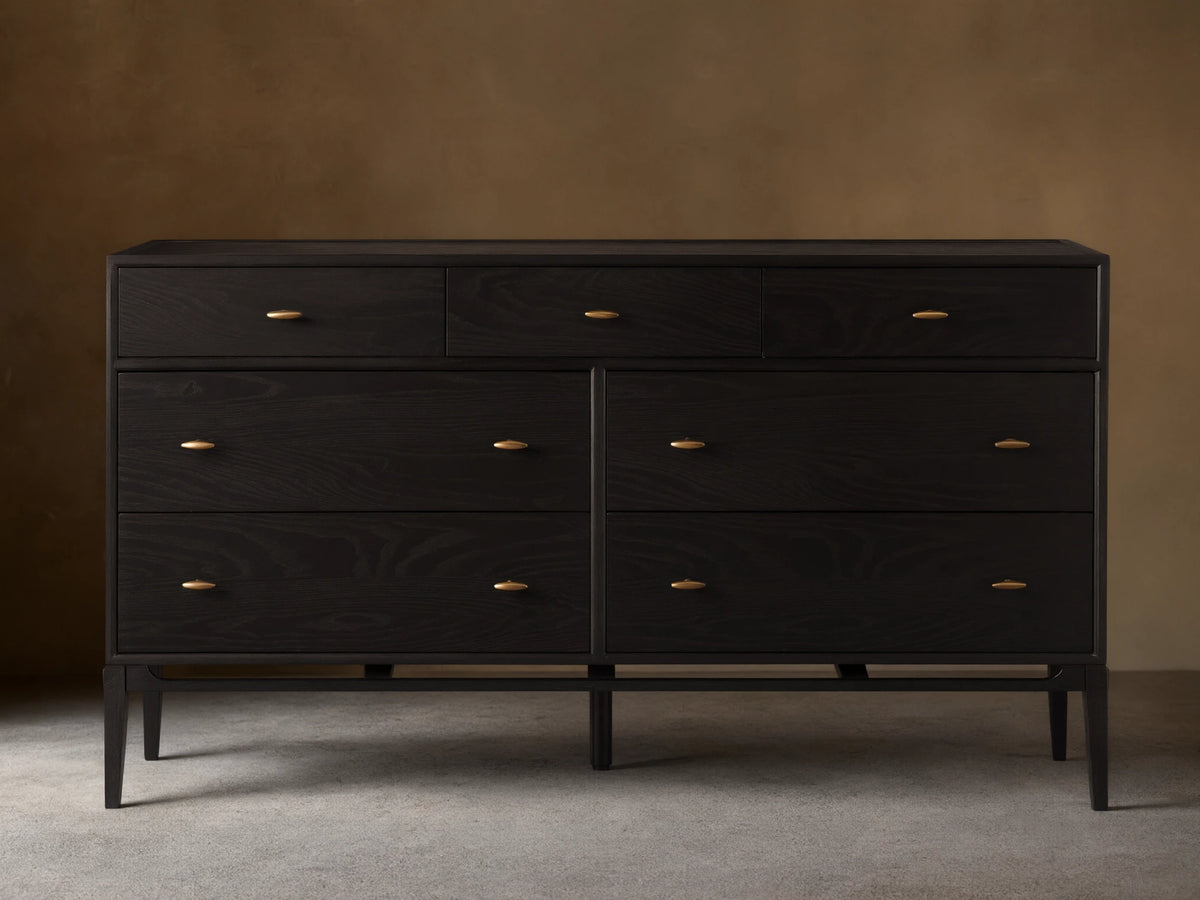 Brock Seven-Drawer Dresser in dark ash wood with a subtle sheen, featuring brushed brass handles, shown against a neutral background.