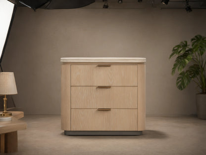 Caden Nightstand, sand finish oak veneer, light stone top, 3 drawers with pewter edge-pulls, on wood floor.