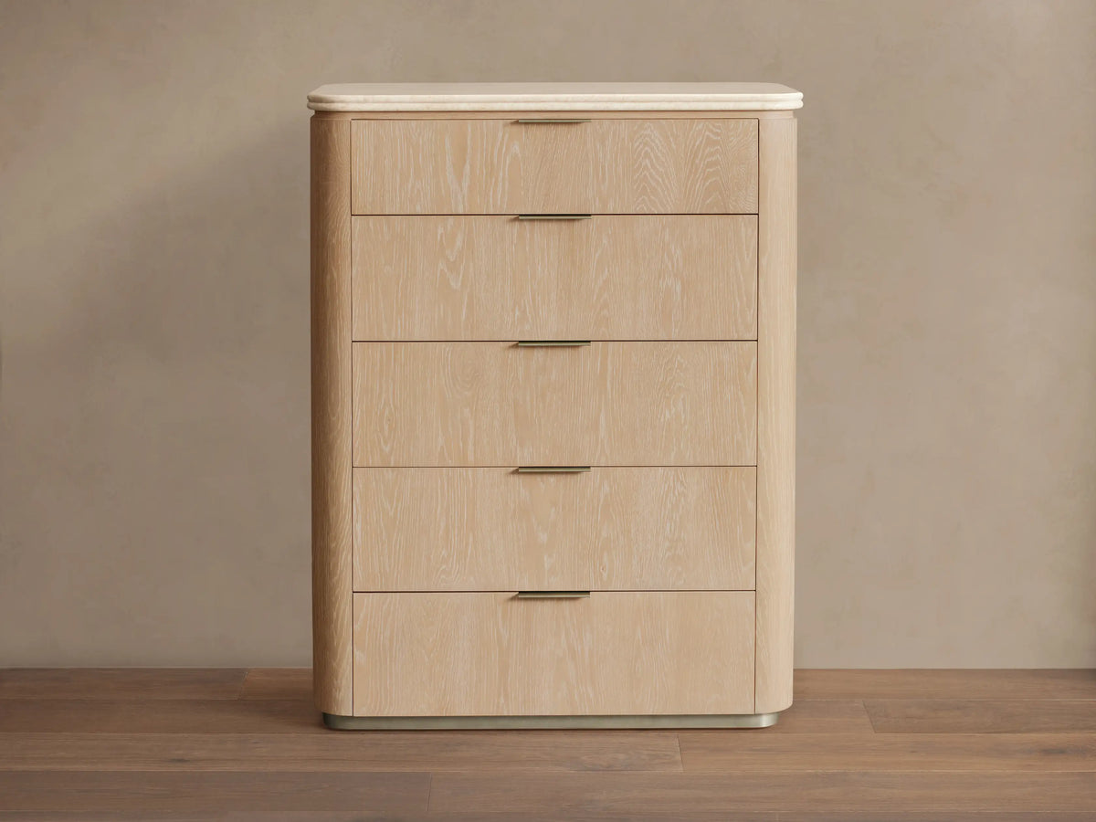 Caden Five-Drawer Dresser with sand oak veneer, rounded edges, white stone top, and five drawers with pewter edge-pull hardware.