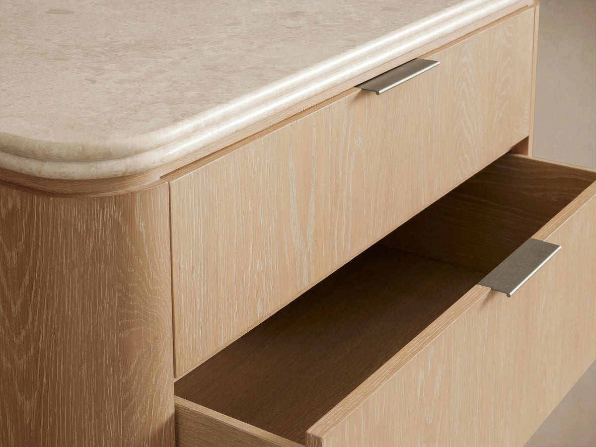 Caden Five-Drawer Dresser with sand oak veneer, rounded edges, white stone top, and five drawers with pewter edge-pull hardware.