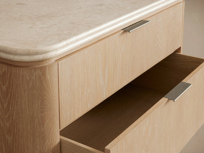 Caden Five-Drawer Dresser with sand oak veneer, rounded edges, white stone top, and five drawers with pewter edge-pull hardware.