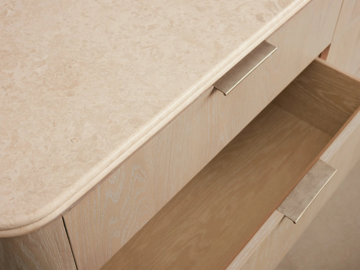 Caden Six-Drawer Dresser in sand-finished oak veneer, with a light stone top, six drawers, and pewter edge-pull hardware.