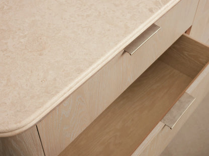 Caden Six-Drawer Dresser in sand-finished oak veneer, with a light stone top, six drawers, and pewter edge-pull hardware.