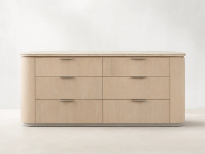 Caden Six-Drawer Dresser in sand finish oak veneer, with a light stone top, pewter edge-pulls, and rounded corners.