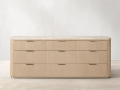 Caden Nine-Drawer Dresser: light sand oak veneer with rounded edges, a light stone top, and pewter hardware.