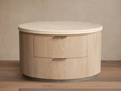 Caden Oval Nightstand in light sand oak veneer with visible grain, two drawers with pewter pulls, and a cream stone top.