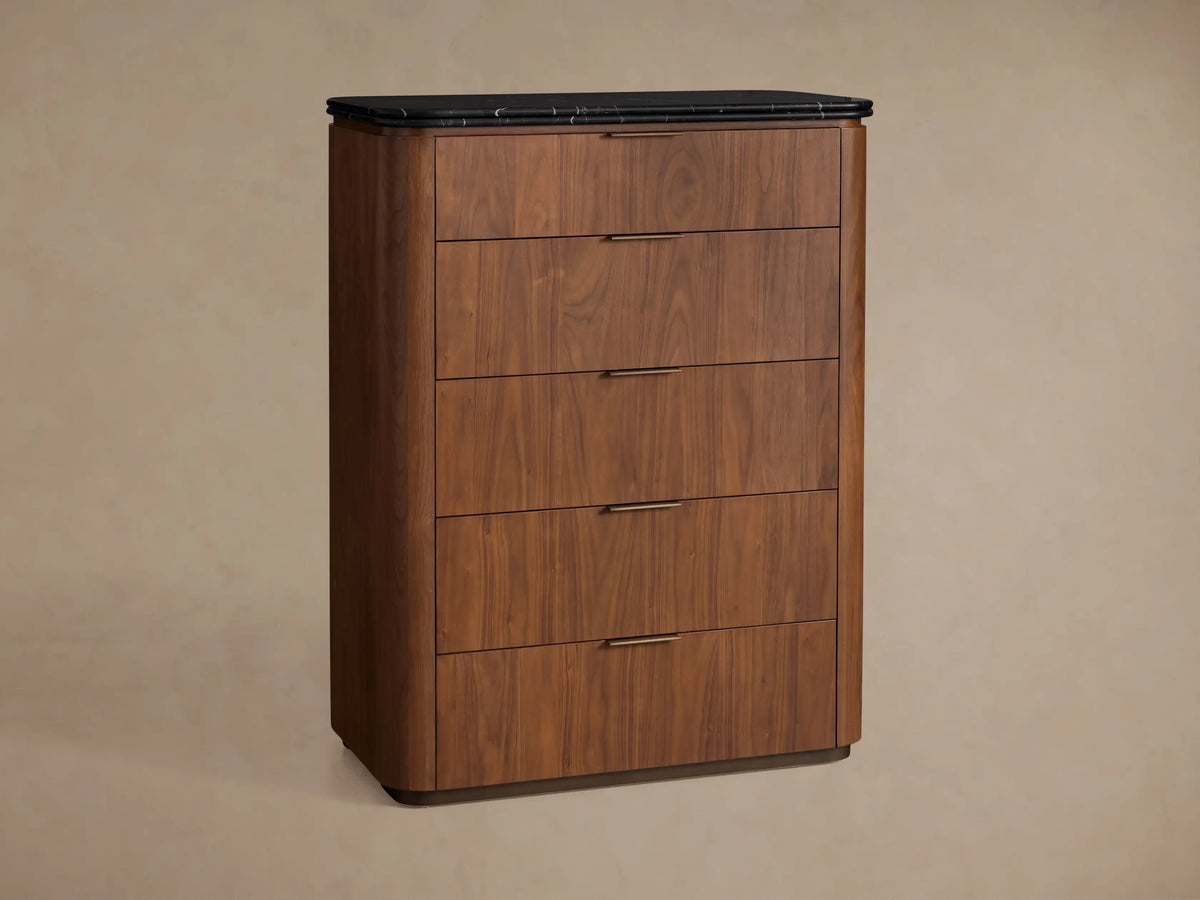 Caden Five-Drawer Dresser close-up: dark walnut wood with black marble top. Bottom drawer open, antique bronze handle.