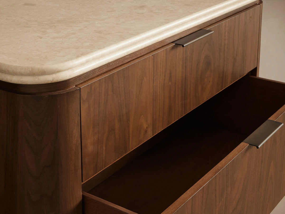 Caden Five-Drawer Dresser in light walnut wood, rounded sides, white stone top, 5 drawers with antique bronze pulls.