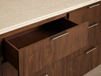 Caden Nine-Drawer Dresser in dark walnut wood veneer with light stone top, 9 drawers, rounded sides, antique bronze edge pulls.