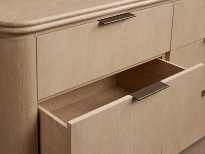 Front view of the sand finish Caden Wood Nine-Drawer Dresser with nine drawers, dark edge-pull hardware, and a rounded top.
