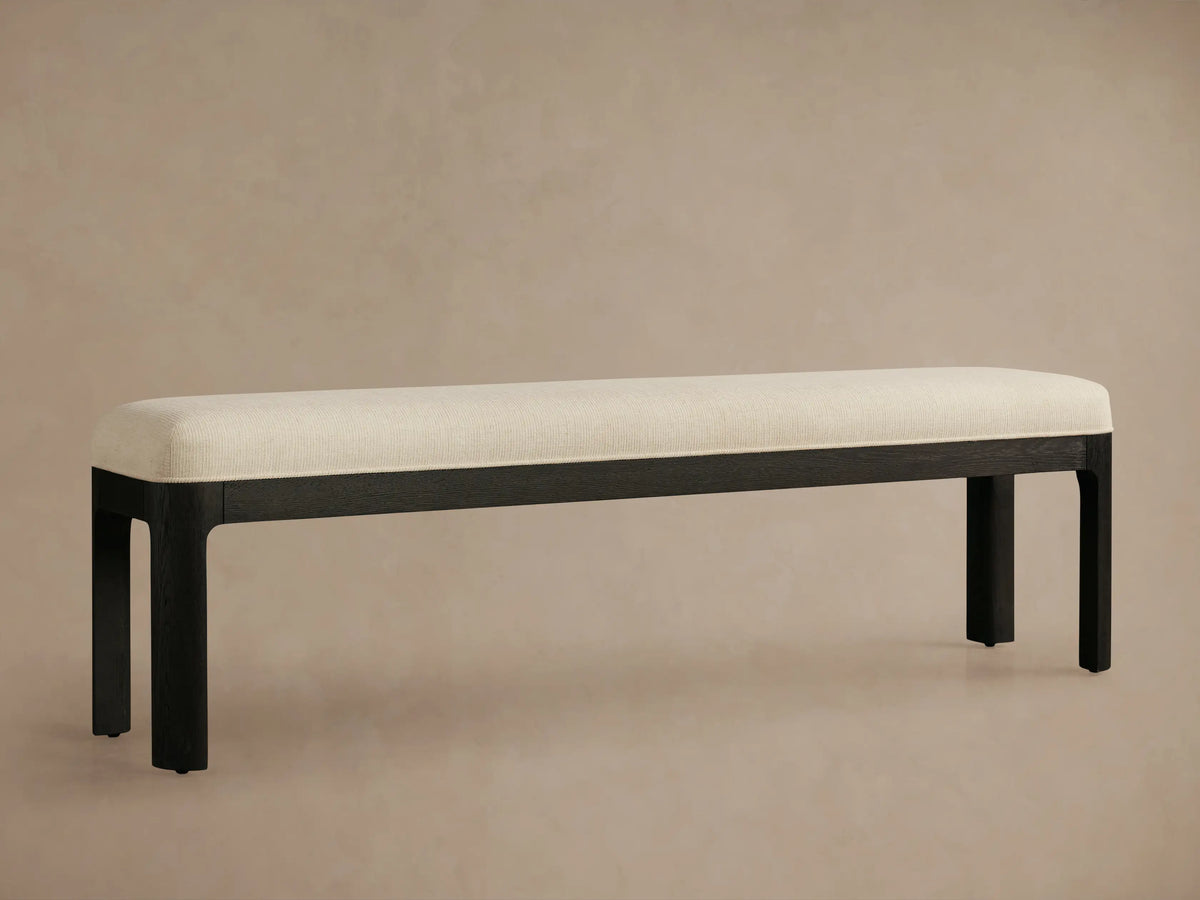 Calista Bench with a cream, ribbed upholstered seat on a dark, satin-finished oak wood frame and square legs.