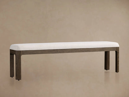 Calista Bench with white cushioned seat, dark oak legs, and minimal design against a plain beige background.