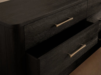 Calista Six-Drawer Dresser in dark brown oak, featuring six drawers with horizontal gold bar pulls and rounded corners, on a wood floor.