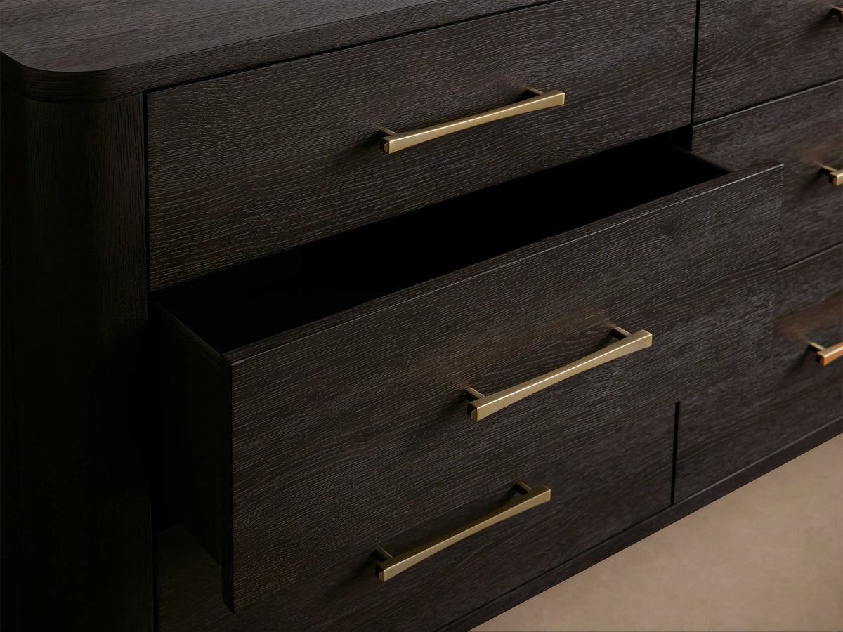 Dark espresso Calista nine-drawer dresser with sleek gold bar pulls, viewed front-on against a light beige wall.