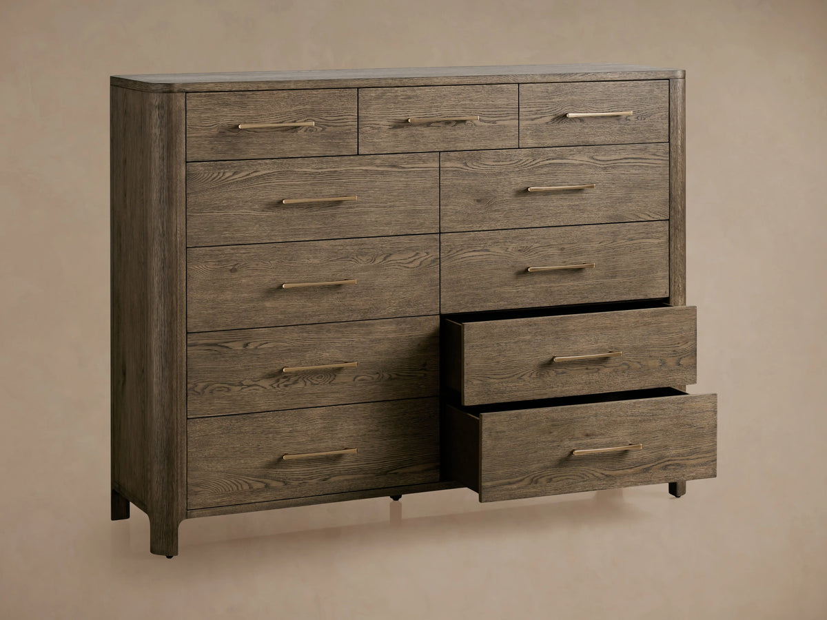 Calista Eleven-Drawer Dresser in oak wood with visible grain, featuring eleven drawers with metal handles, on a wooden floor.