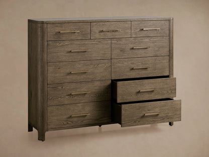 Calista Eleven-Drawer Dresser in oak wood with visible grain, featuring eleven drawers with metal handles, on a wooden floor.