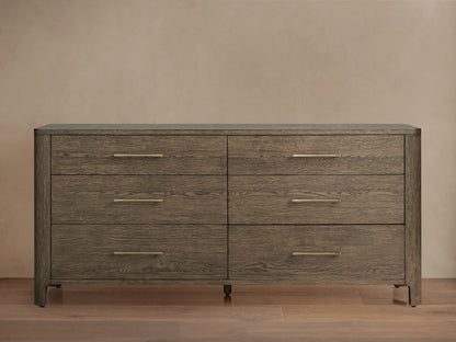 Calista Six-Drawer Dresser in veneered oak with a satin finish, featuring sleek brass handles and wood grain texture.