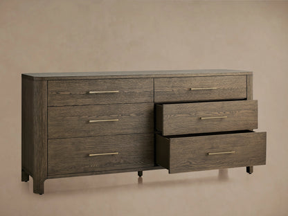Calista Six-Drawer Dresser in dark veneered oak finish, featuring six drawers with gold handles, two slightly open, against a beige background.