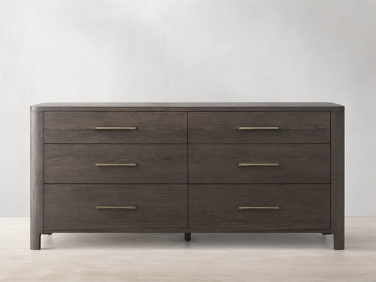 Calista Six-Drawer Dresser in veneered oak with a satin finish, featuring sleek brass handles and wood grain texture.