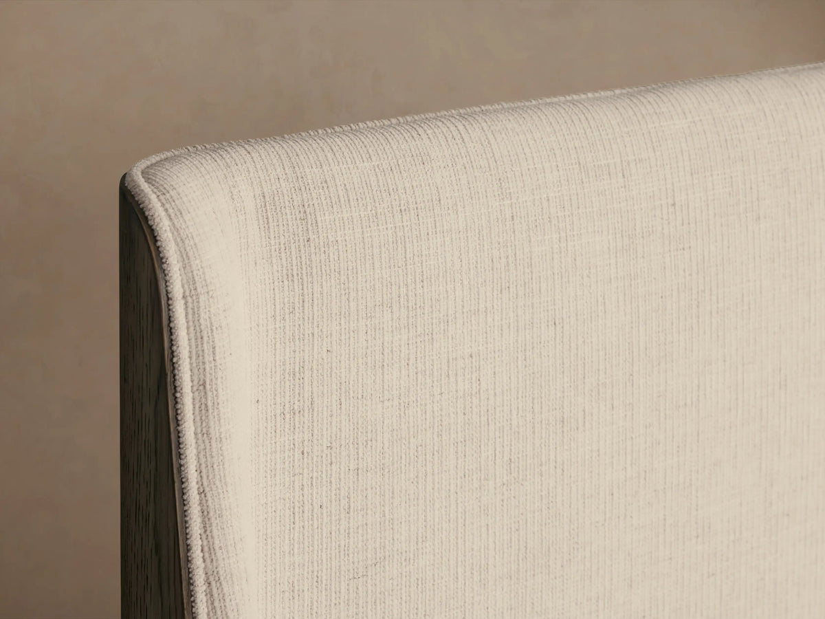 Calista Bed with creamy white upholstered headboard, dark oak frame, and white duvet & pillows. Front view.
