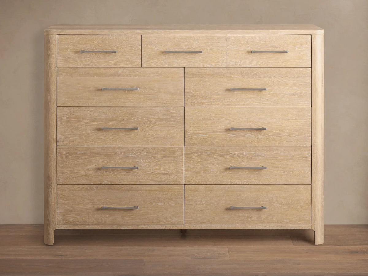 Calista Eleven-Drawer Dresser, light oak wood grain, featuring 3 small top drawers & 8 larger, with silver bar handles.