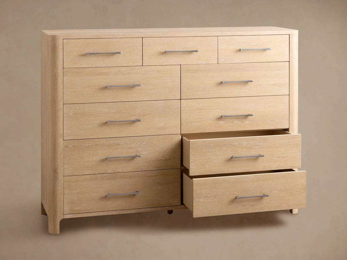 Calista Eleven-Drawer Dresser, light oak wood grain, featuring 3 small top drawers & 8 larger, with silver bar handles.