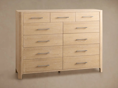 Calista Eleven-Drawer Dresser, light oak with visible grain. One drawer is open, revealing a dark interior; others show dark gray handles.