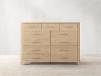 Calista Eleven-Drawer Dresser, light oak wood grain, featuring 3 small top drawers & 8 larger, with silver bar handles.